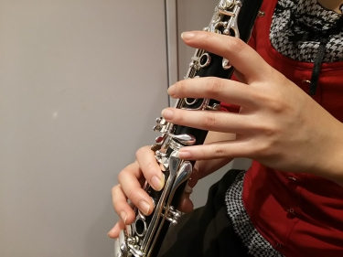 クラリネットの運指を確認しながら練習する生徒