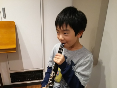 楽しそうにクラリネットに息を吹き込む子供
