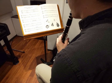 楽譜を見ながら座って演奏する生徒