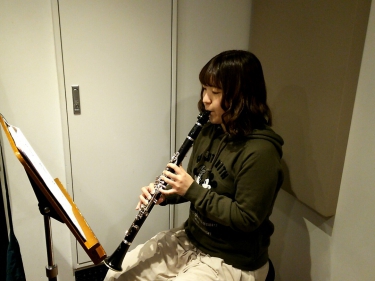 楽譜を見ながら座って演奏する生徒