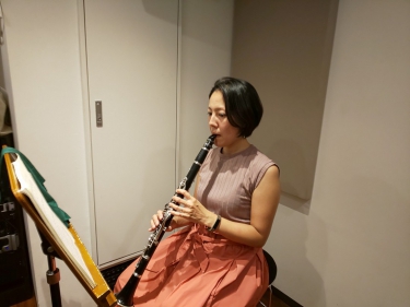 楽譜を見ながら座って演奏する生徒