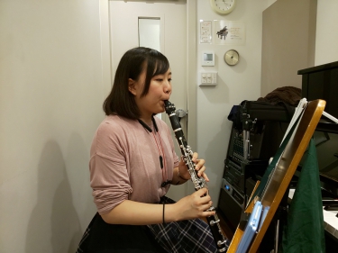 楽譜を見ながら座って演奏する生徒