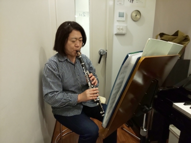 楽譜を見ながら座って演奏する生徒