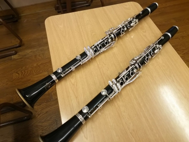 学校の机に正しく置かれた2本のクラリネット