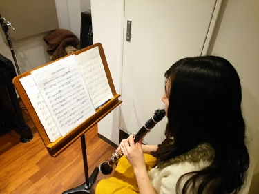 楽譜を見ながらクラリネットを演奏する生徒