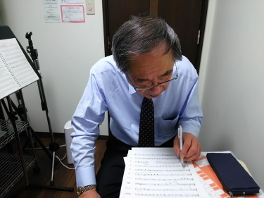 楽譜にメモを書き込み楽曲を確認する生徒