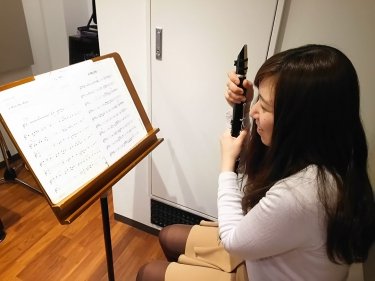クラリネットを抱えて楽譜を眺める生徒