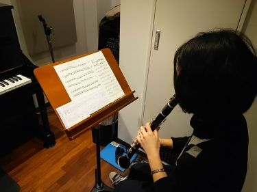 譜面台に置かれた楽譜を見ながらレッスンを受ける生徒