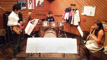 ベースとドラムと一緒にクラリネットを演奏する生徒