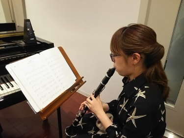 譜面台の楽譜を見ながらクラリネットを学ぶ生徒