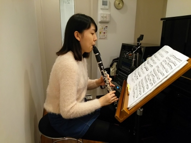 楽譜を見ながら座って演奏する生徒