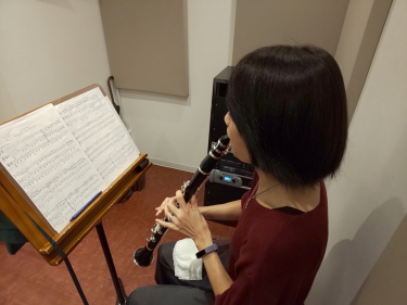 楽譜を見ながら座って演奏する生徒