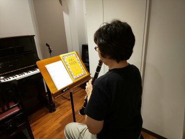 楽譜を見ながら座って演奏する生徒