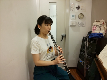 楽譜を見ながら座って演奏する生徒