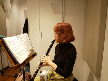 楽譜を見ながら座って演奏する生徒