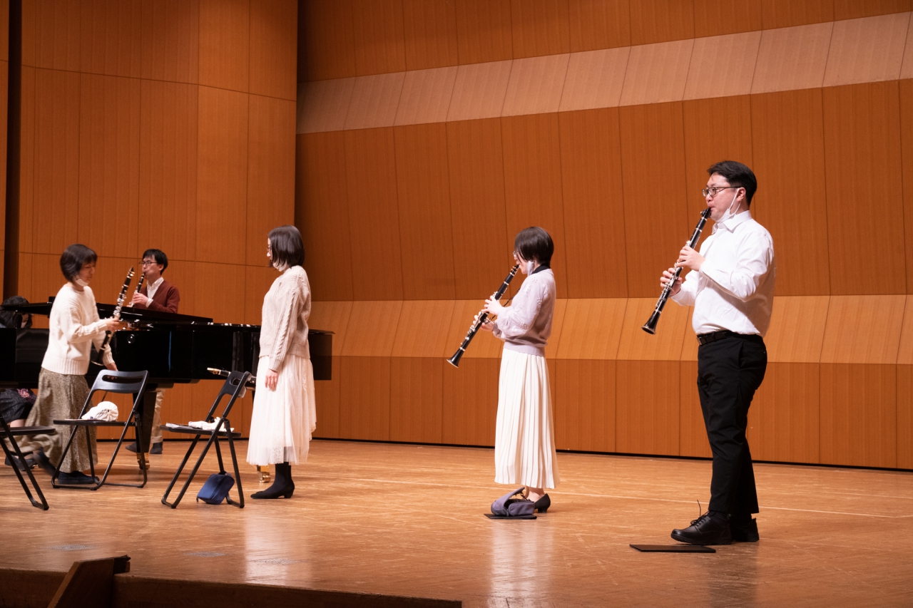 ホールのステージで音出しをする生徒達