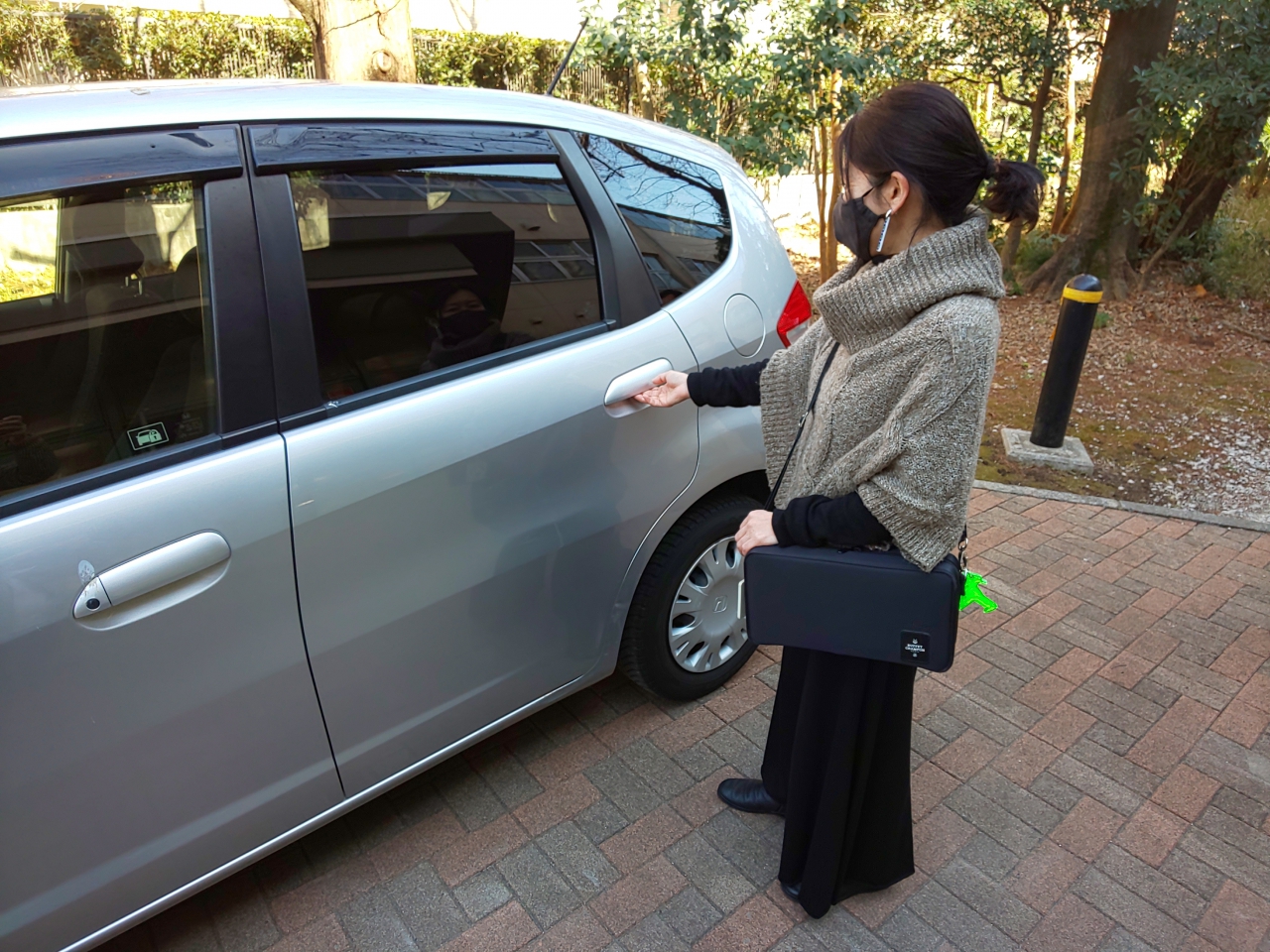 車で練習をするためにドアに手をかけるクラリネット奏者