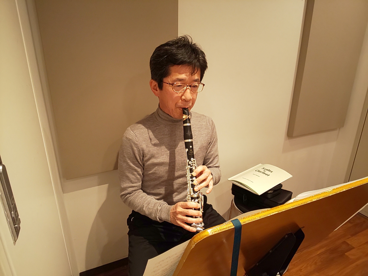 楽譜を見ながら座って演奏する生徒