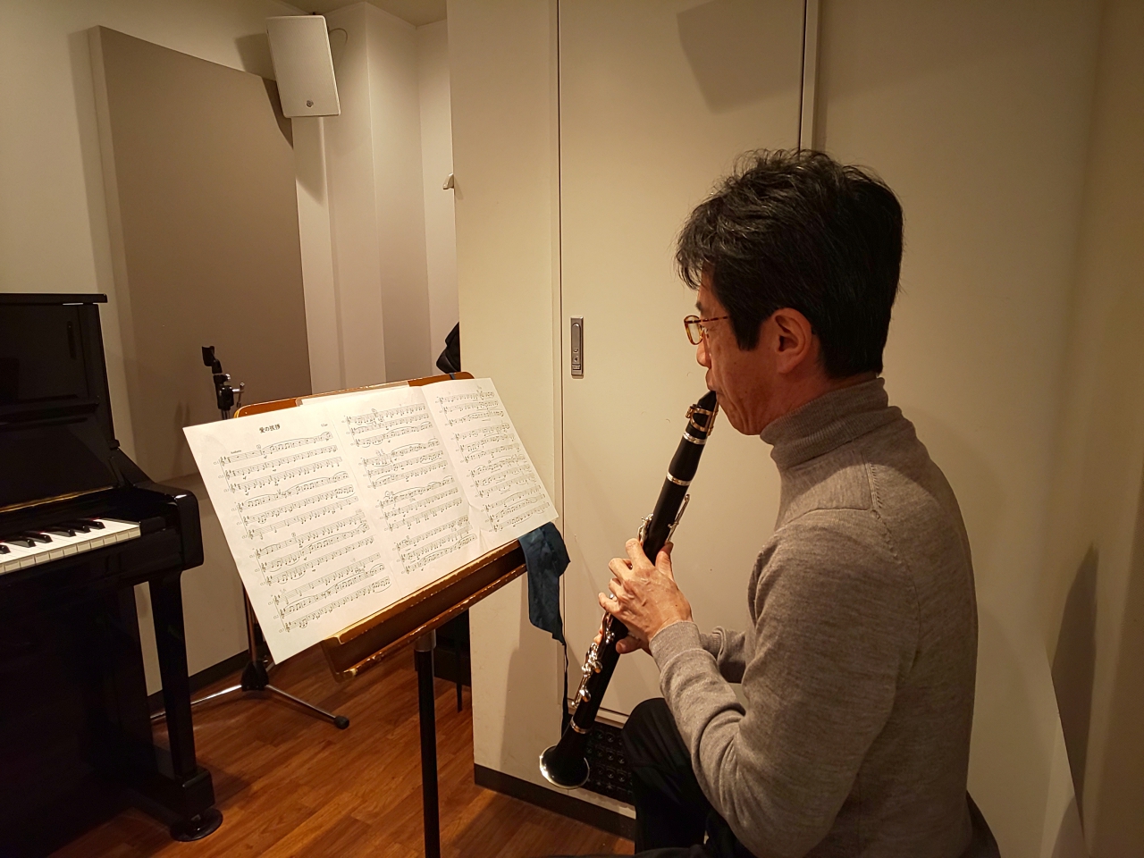 楽譜を見ながら座って演奏する生徒