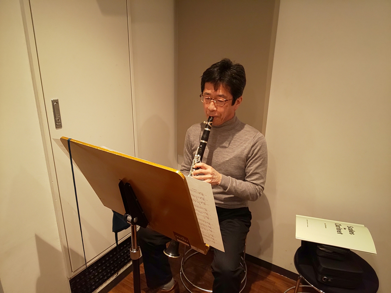 楽譜を見ながら座って演奏する生徒