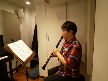 楽譜を見ながら座って演奏する生徒