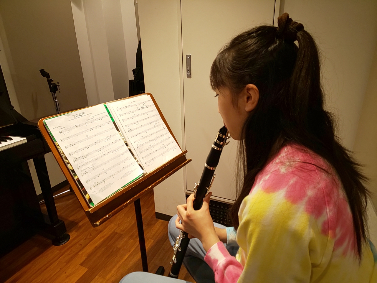 楽譜を見ながら座って演奏する生徒
