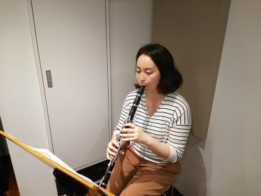 楽譜を見ながら座って演奏する生徒