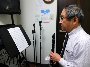 譜面台に置かれた楽譜を見る生徒