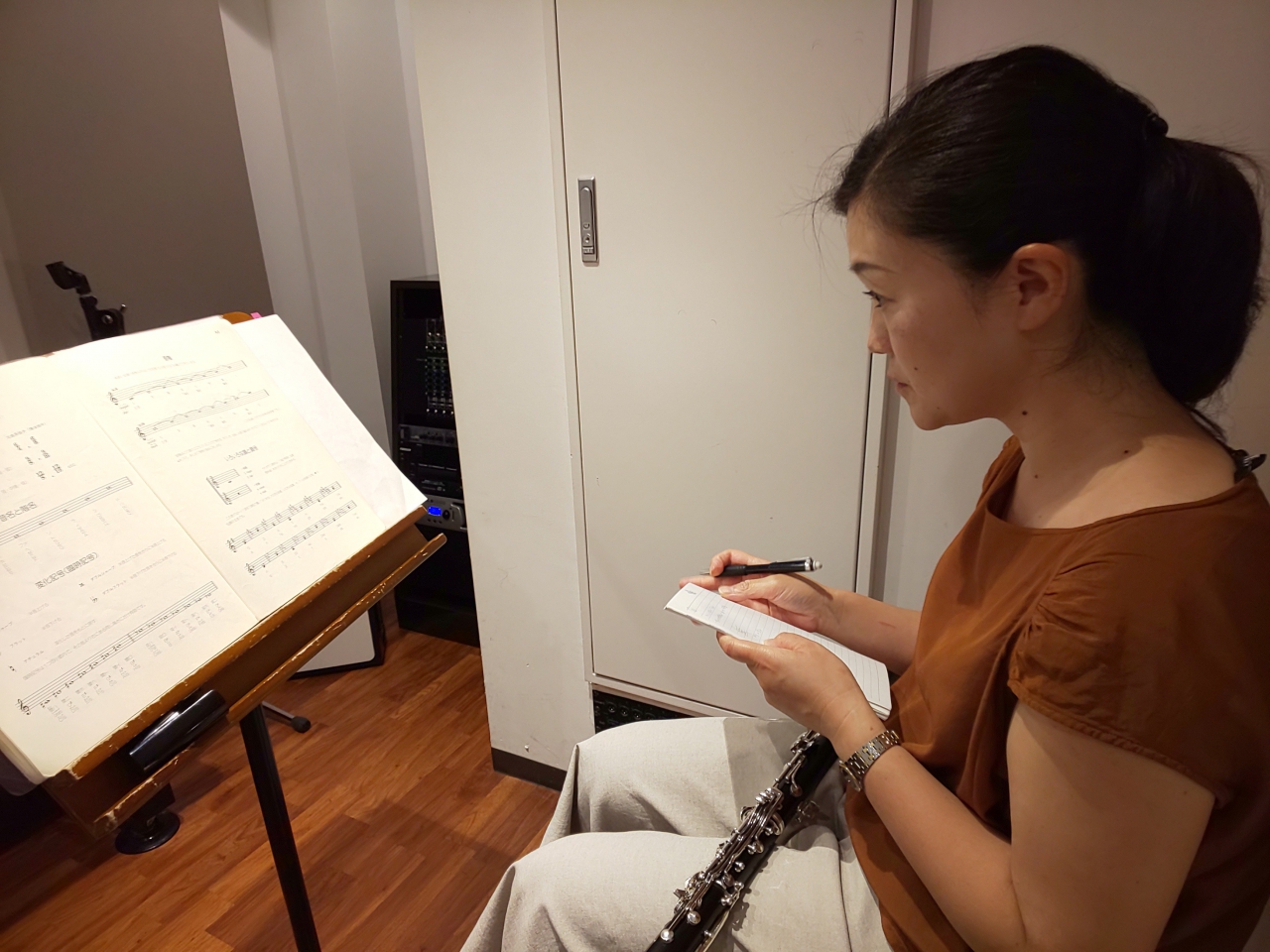 楽譜を見ながら要点をメモする生徒