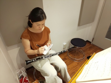 楽譜を見ながら要点をメモする生徒