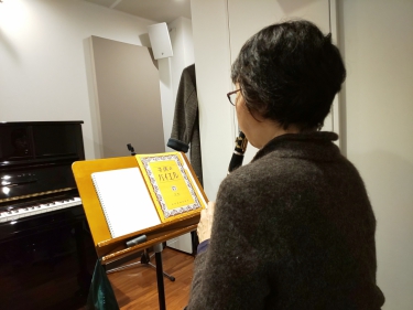 楽譜を見ながら座って演奏する生徒