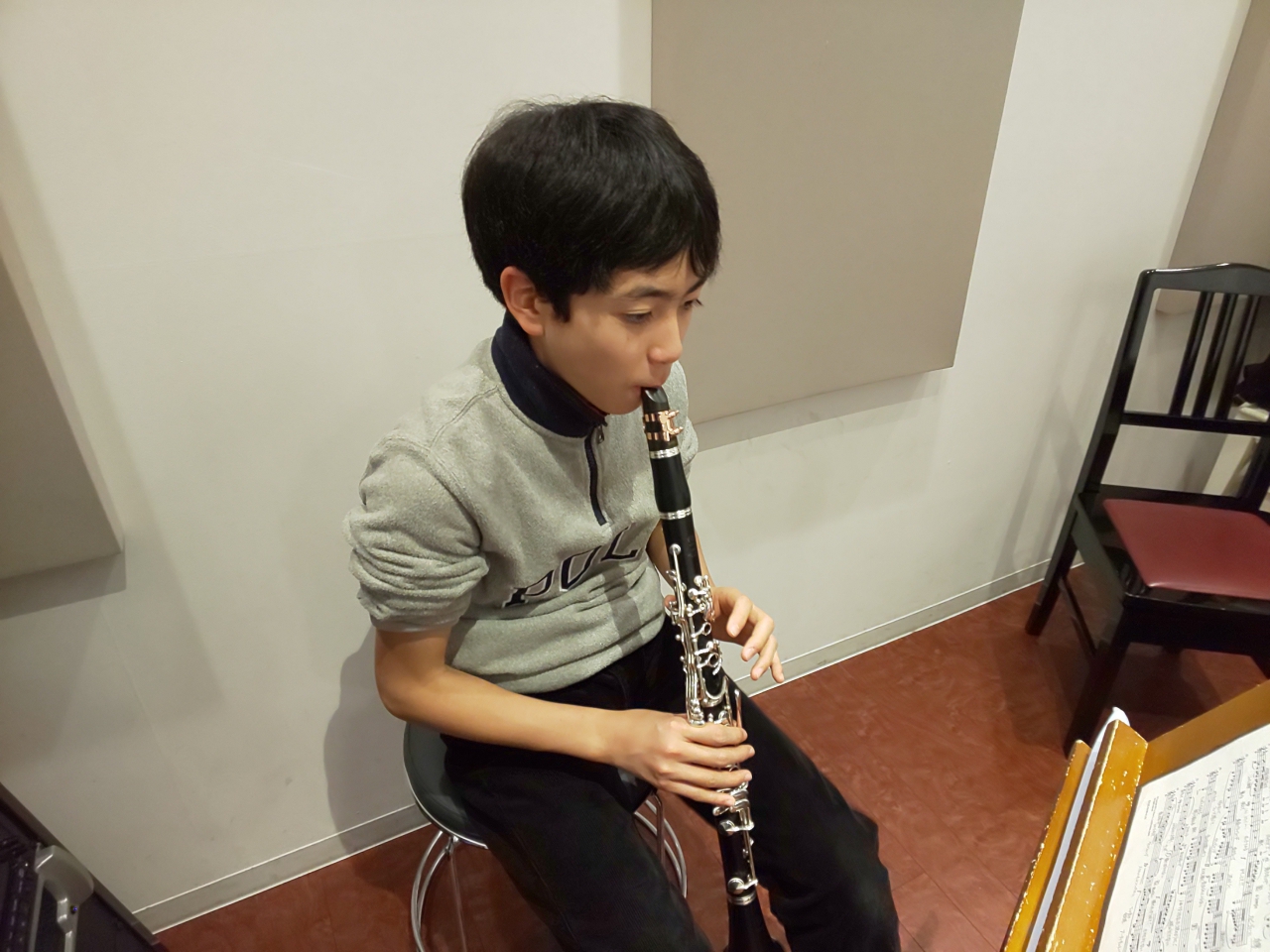 楽譜を見ながら座って演奏する生徒