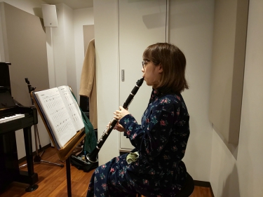 楽譜を見ながら座って演奏する生徒