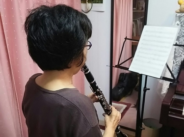 楽譜を見ながら座って演奏する生徒