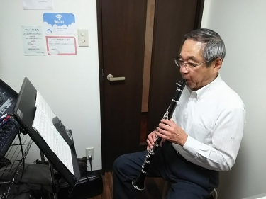 楽譜を見ながら座って演奏する生徒