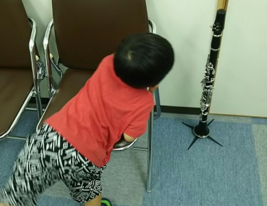 スタンドに立てられたクラリネットに興味を持つ子供